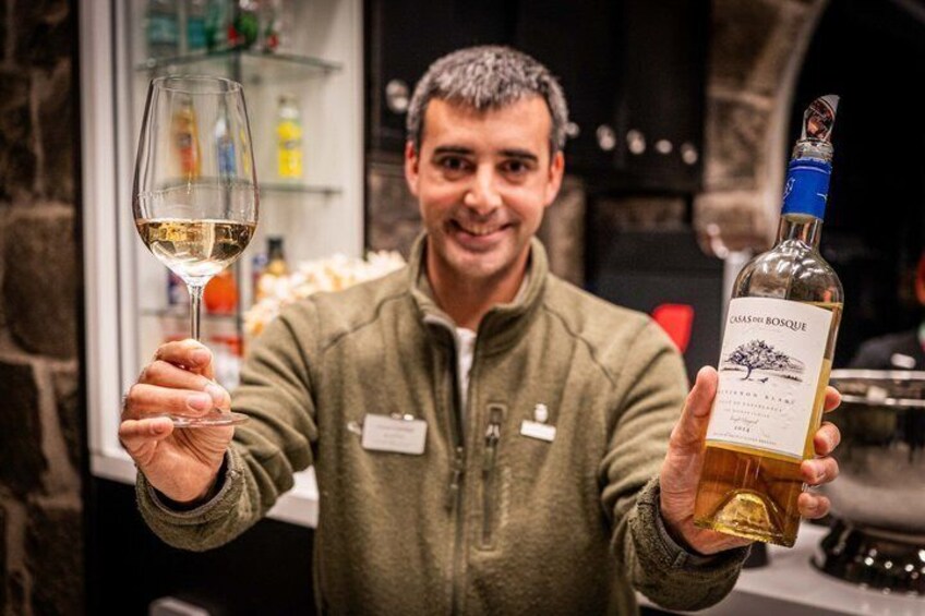 A person holding a wine glass and a bottle of wine. 4