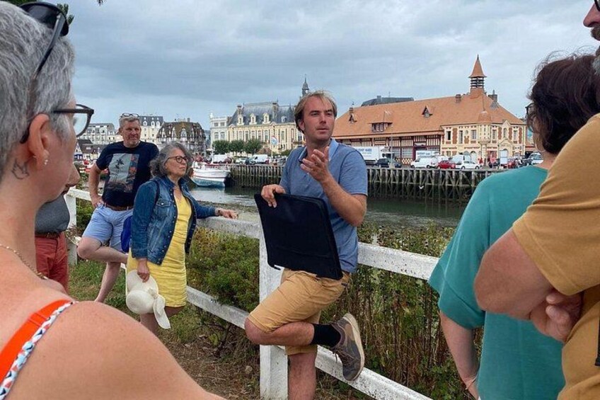 Un grupo de personas junto a la costa, con un edificio histórico al fondo. 3