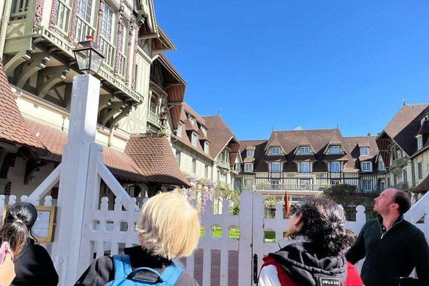 Un edificio de estilo europeo tradicional con una cerca blanca en primer plano. 5