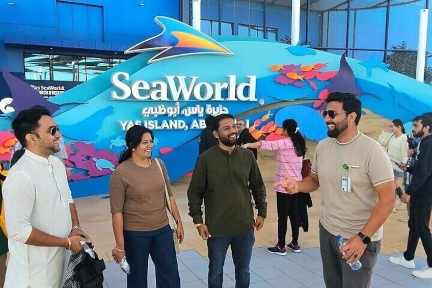 Eine Gruppe von Menschen steht vor einem bunten SeaWorld-Schild. 2