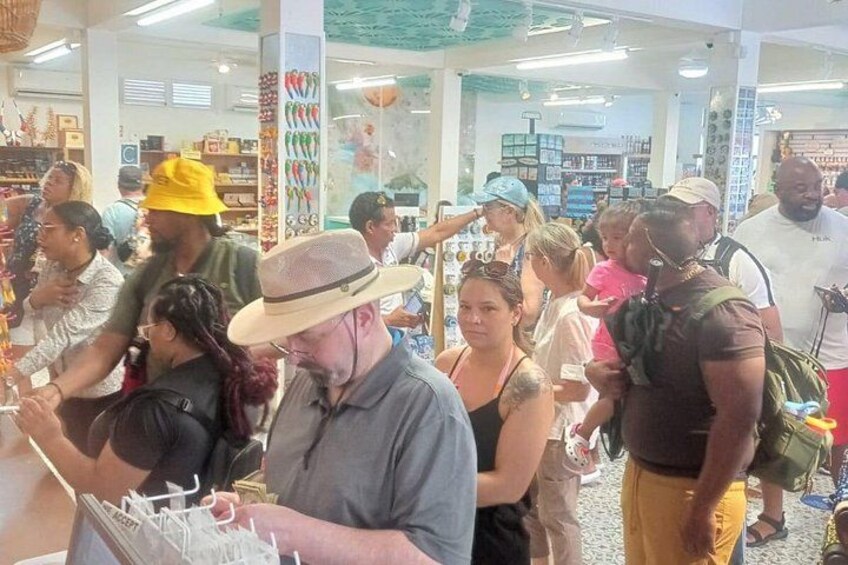 A crowded indoor market with people browsing and shopping. 2