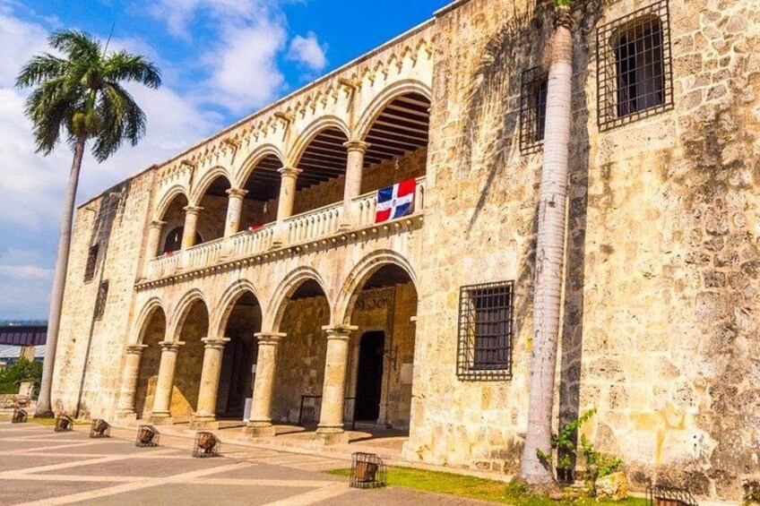 Un bâtiment historique doté d’arcades et arborant un drapeau. 2