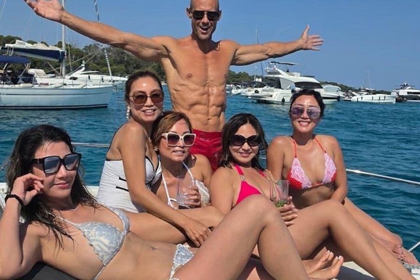 A group of people on a boat with a marina in the background. 1