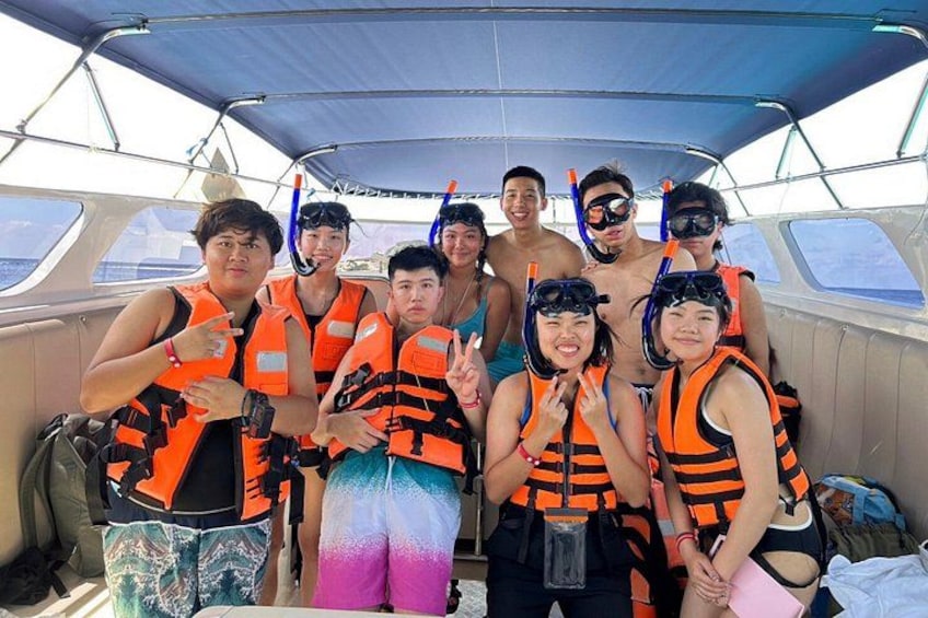 A group of people on a boat wearing life jackets and snorkeling gear. 2