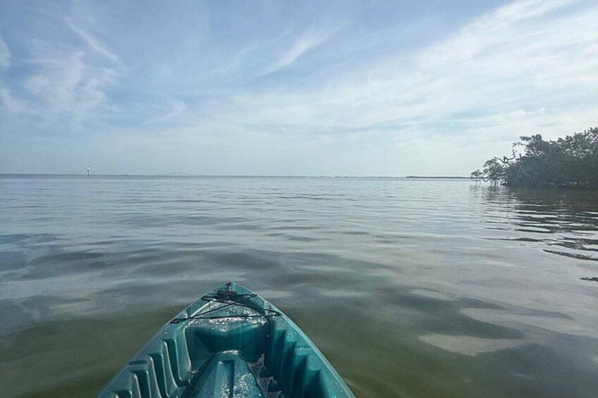 Rustig waterlichaam met een boot op de voorgrond en een verre oever met bomen. 2
