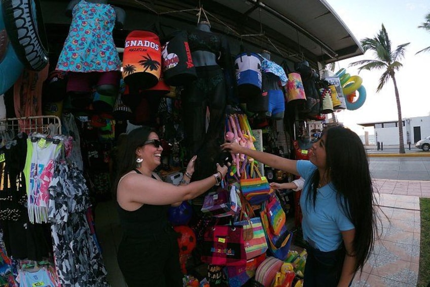 A street market with various colorful hats and bags on display. 3