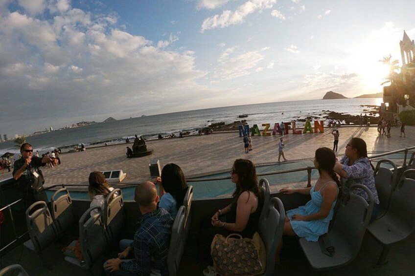 A group of people on a boat with a view of the sea and a beach in the background. 4
