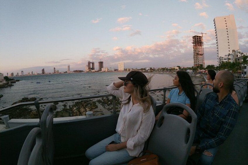 A group of people on a boat with a city skyline and water in the background. 2