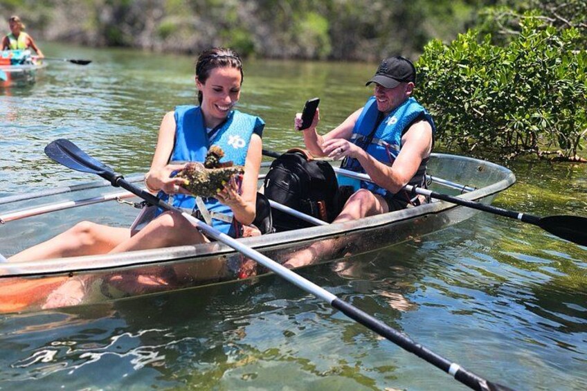 Dos personas en un canoa sobre un río tranquilo, una sosteniendo un teléfono inteligente. 1