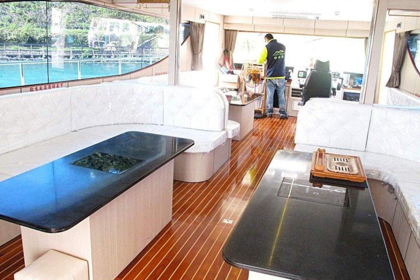 A yacht's interior with a dining area, a kitchen, and a seating area. 2