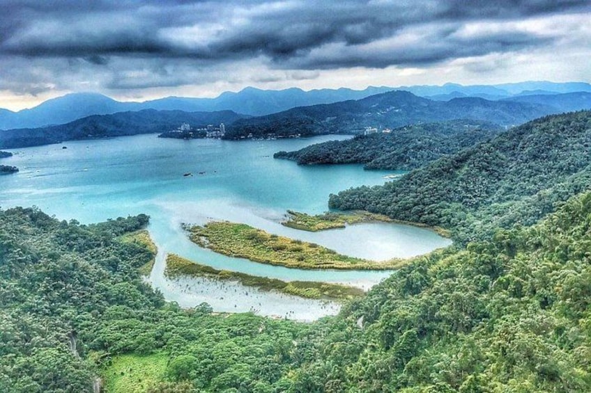 A mountainous landscape with a large lake surrounded by dense forest. 5