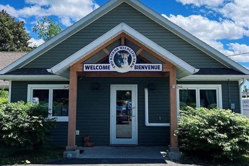 A building with a 'WELCOME' sign and a circular emblem above it. 1