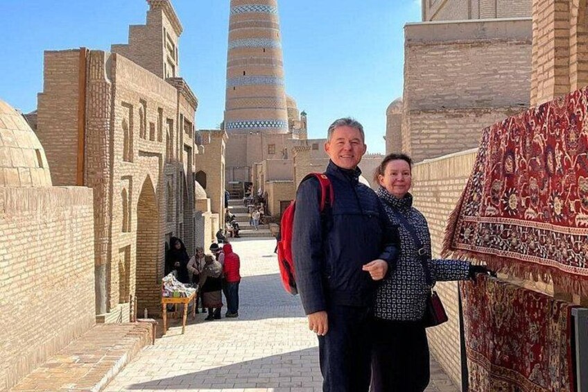 A historic building with a tall minaret, a patterned carpet, and a brick pathway. 4