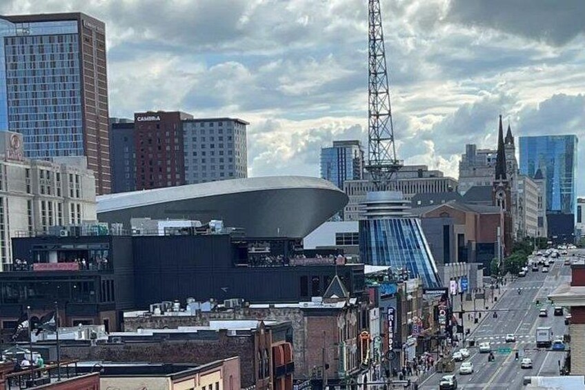Een stadsbeeld met een opvallend modern gebouw, een hoge toren en een combinatie van oudere en nieuwere architectuur. 4