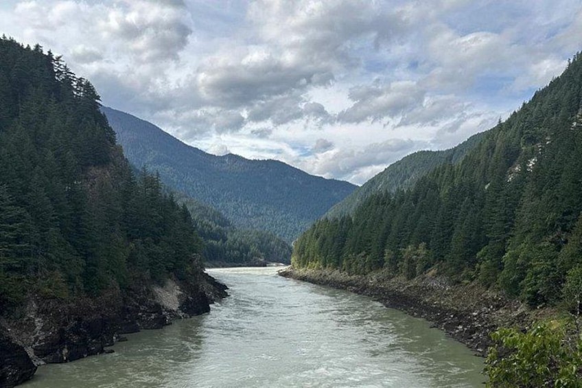 A river flowing through a forested valley with mountains in the background. 2