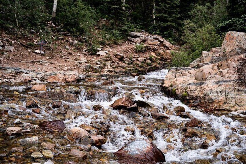 A rocky stream with a cross in the background. 5