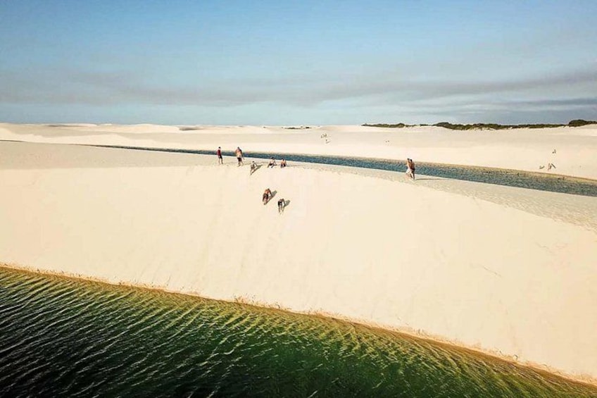 A desert landscape with sand dunes and a water channel. 4