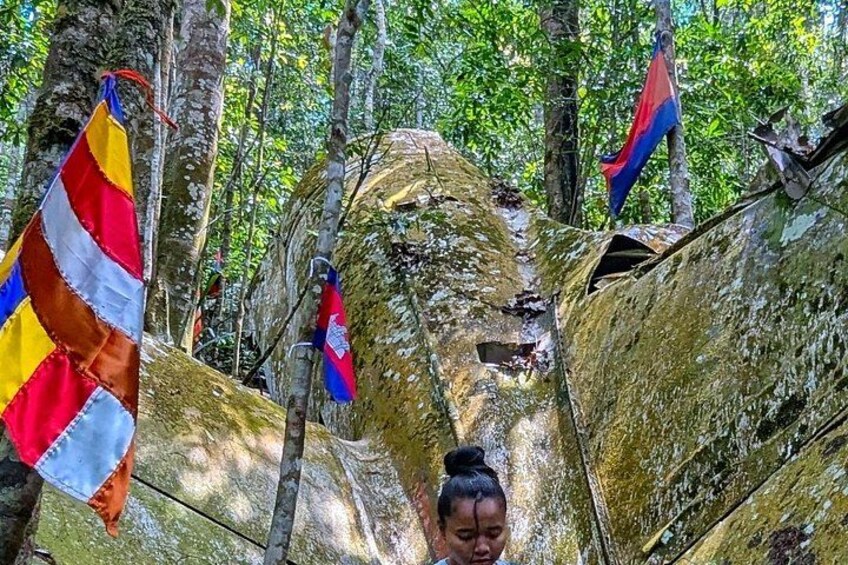 A forested area with a large tree trunk and two flags. 3