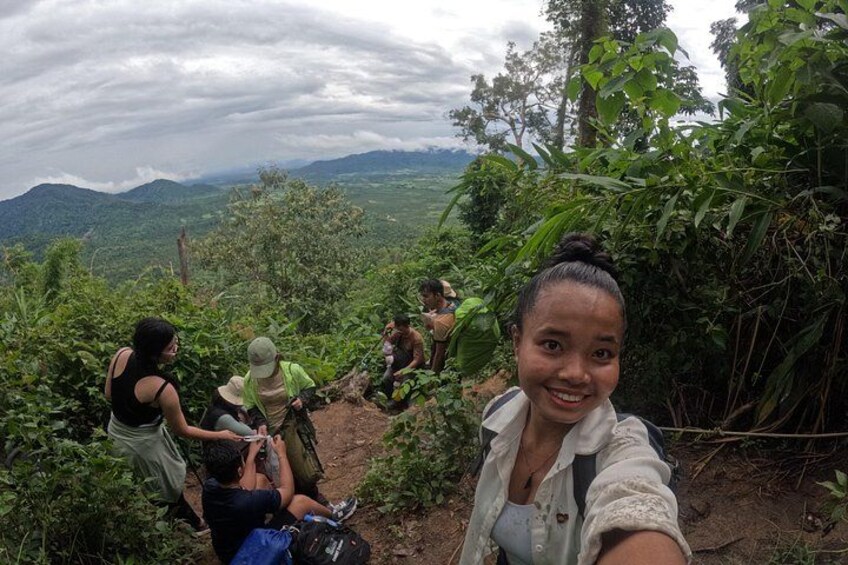 Un grupo de personas caminando por un sendero rodeado de vegetación exuberante y montañas al fondo. 2