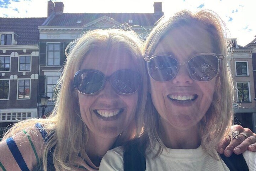 Twee personen staan voor een rij traditionele Nederlandse huizen. 2