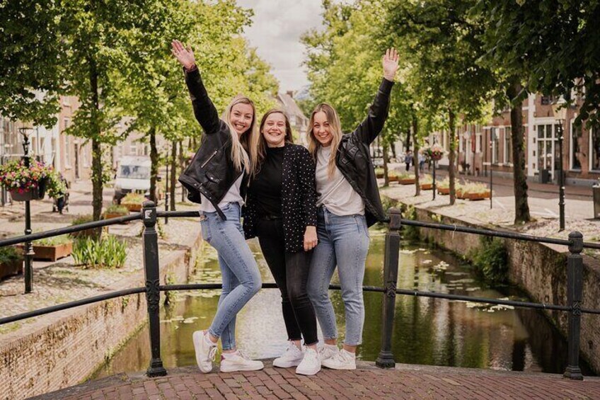 Drie mensen staan op een brug, met de armen omhoog. 1