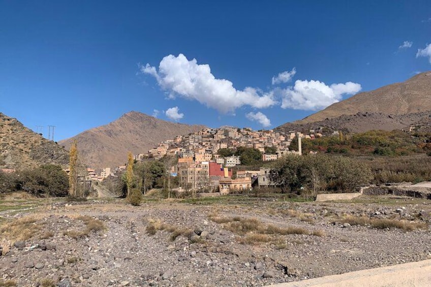 Eine Stadt in den Bergen mit Häusern, wolkenlosem Himmel und felsigem Vordergrund. 2