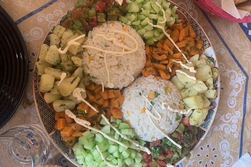 Ein Teller Essen mit Reis, gewürfelten Gemüsesorten und Soße. 5