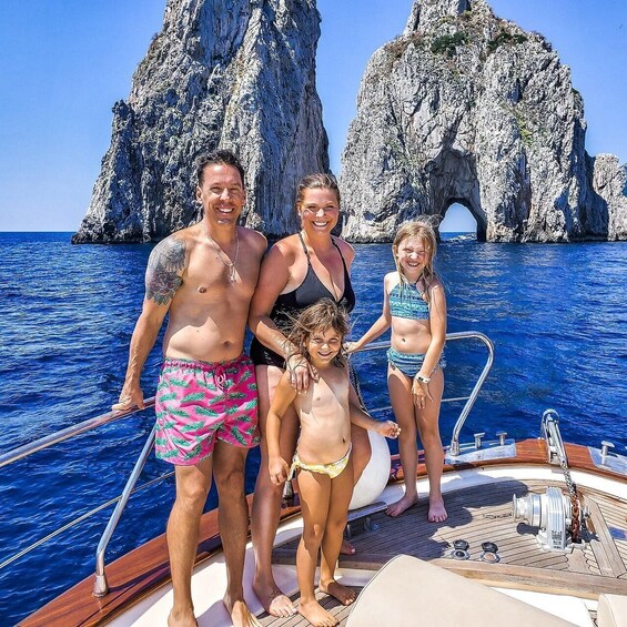 A family on a boat with rocky cliffs in the background. 1
