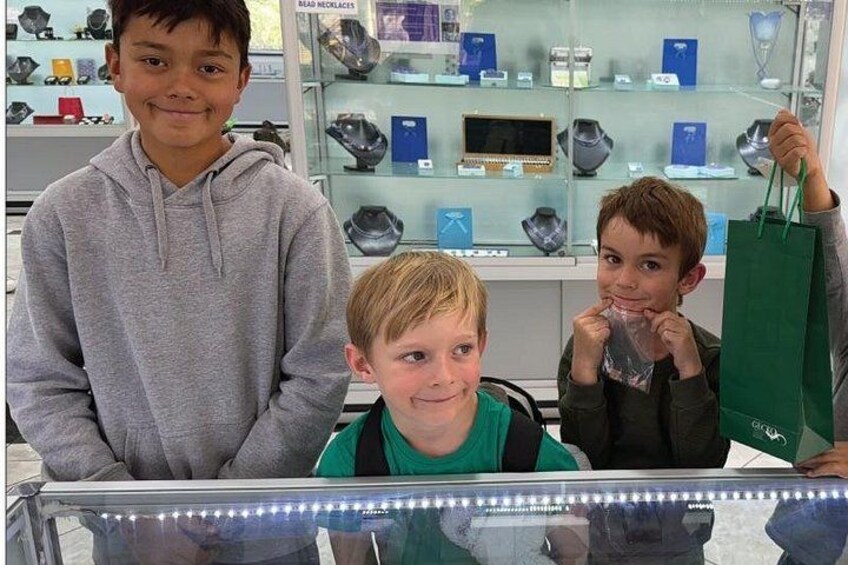Tres niños en una joyería con vitrinas de vidrio. 2
