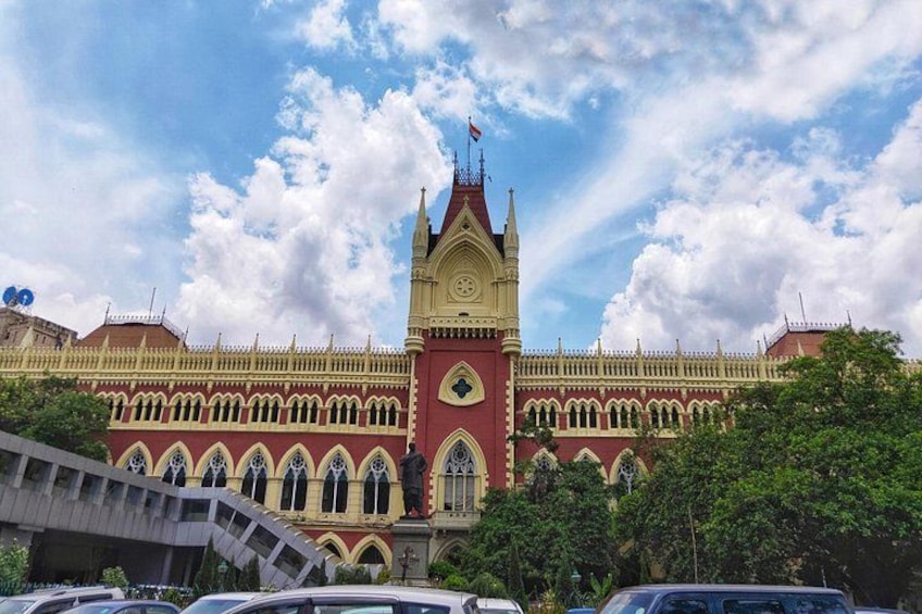 A large, ornate building with a clock tower, arched windows, and a red and yellow facade. 3