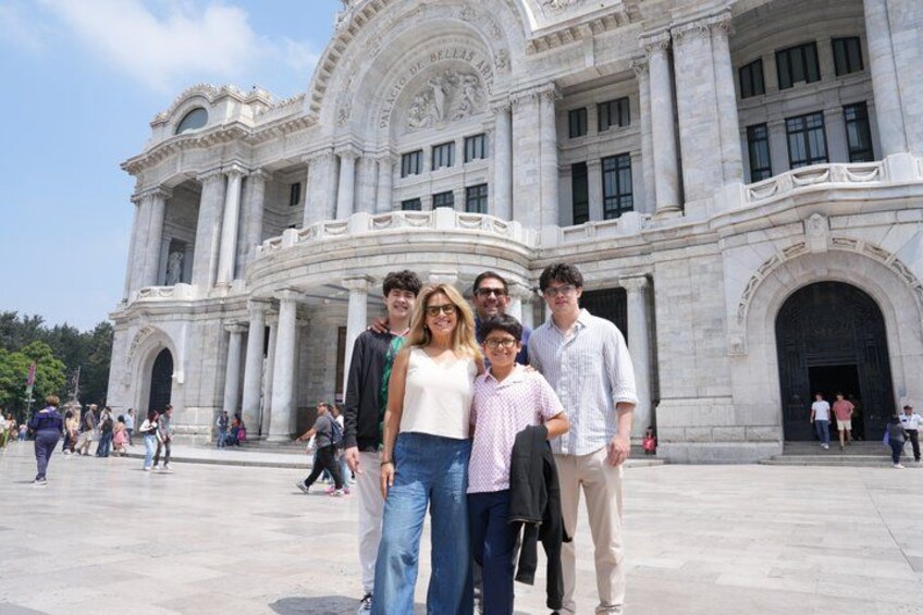 Un grupo de personas frente a un edificio grande y ornamentado, con columnas y arcos. 1
