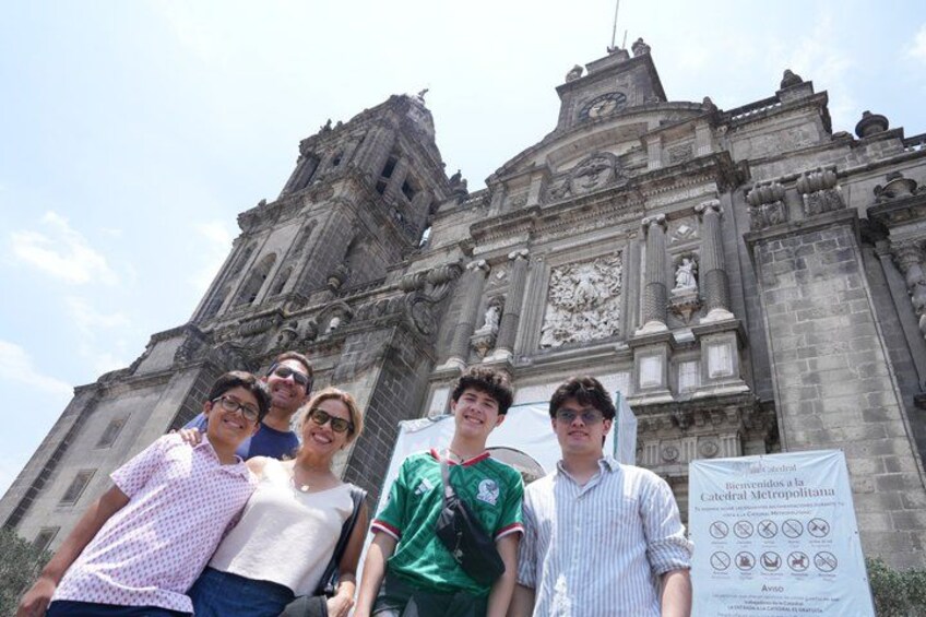 Un grupo de personas frente a una catedral histórica con un cartel. 4