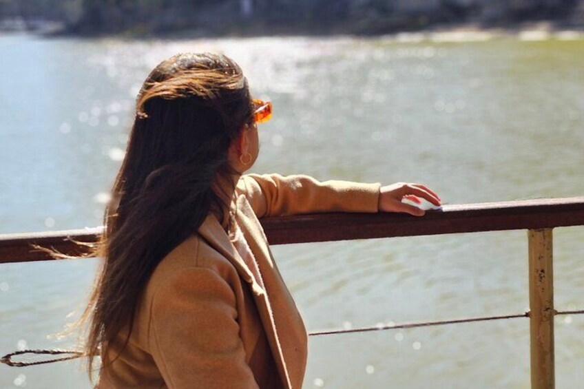A person standing by a railing overlooking a body of water. 2