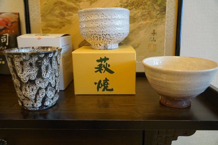 A table with three ceramic bowls and a box with Japanese characters. 2