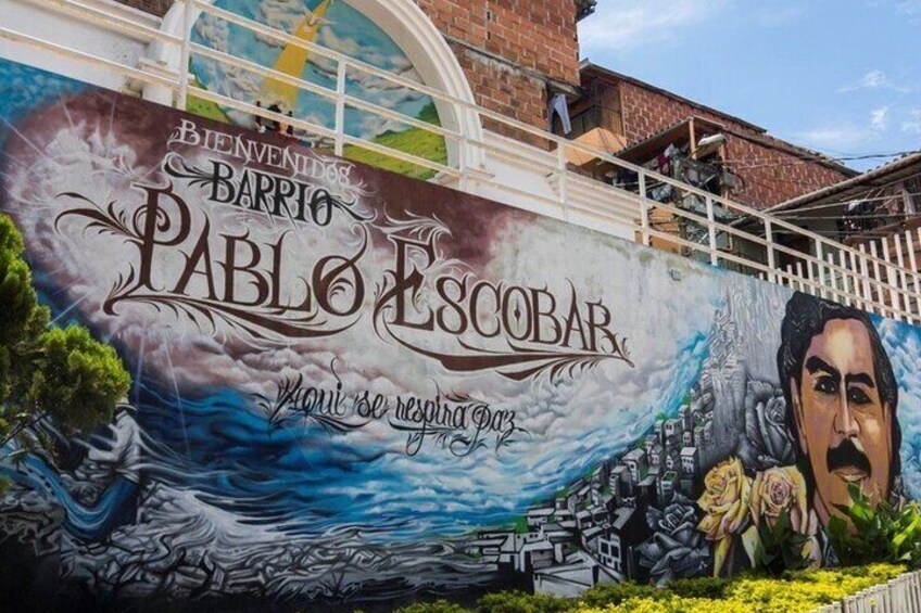 En mural med teksten 'Bienvenidos Barrio Pablo Escobar' og 'Aquí se respira paz'. 1