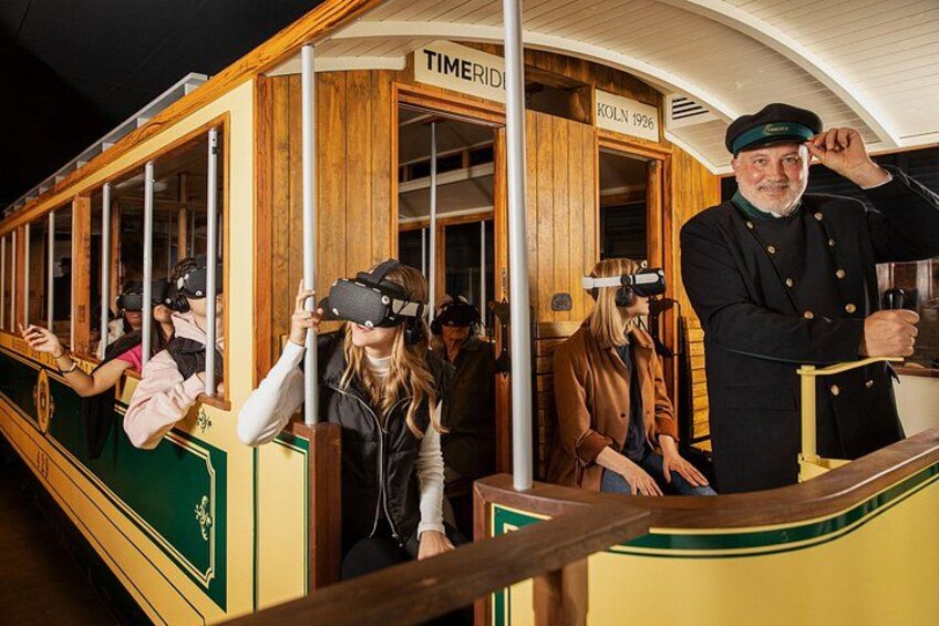 A vintage tram with passengers wearing VR headsets. 5