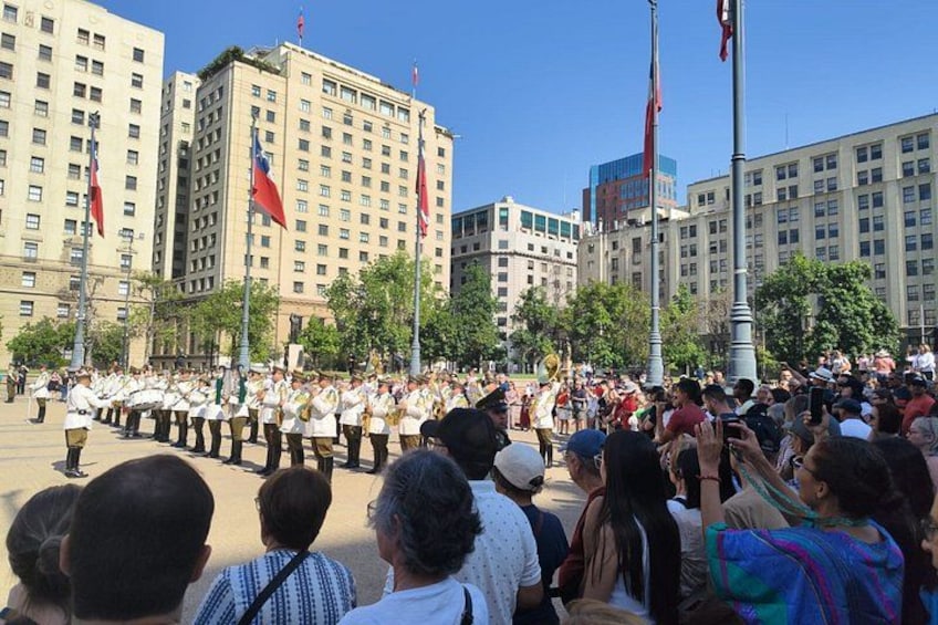 Een militaire parade met soldaten in uniform, toeschouwers en vlaggen in een stedelijke omgeving. 2