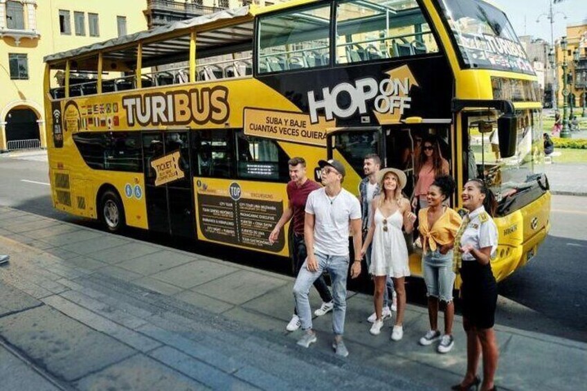 A yellow double-decker bus with "TURIBUS" and "HOP ON OFF" written on it. 3