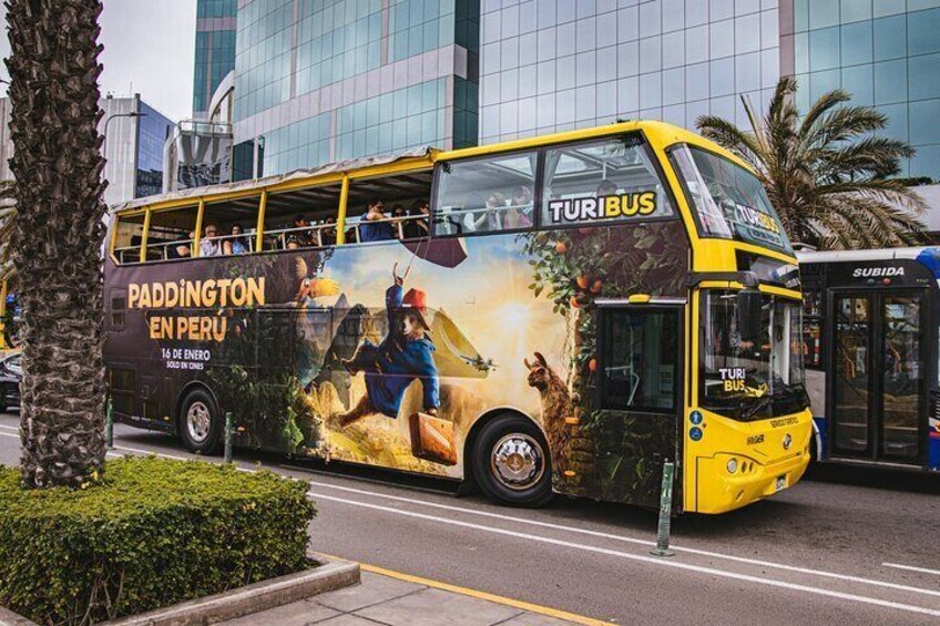 A yellow double-decker bus with an advertisement for Paddington in Peru. 4