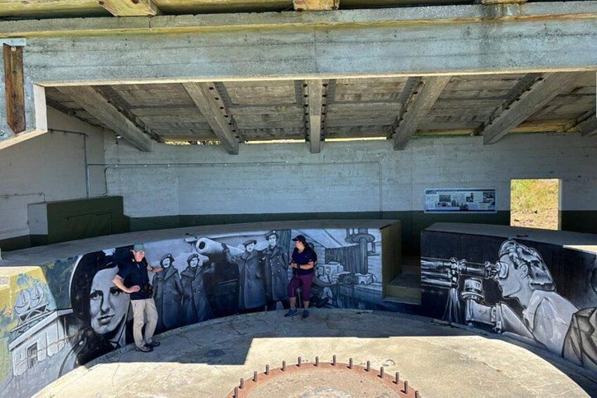 A graffiti-covered wall under a bridge with a person standing in the center. 3