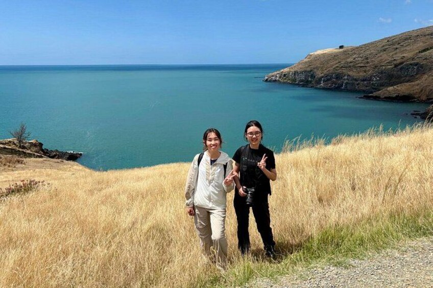 Two people standing on a grassy hill overlooking a body of water. 5