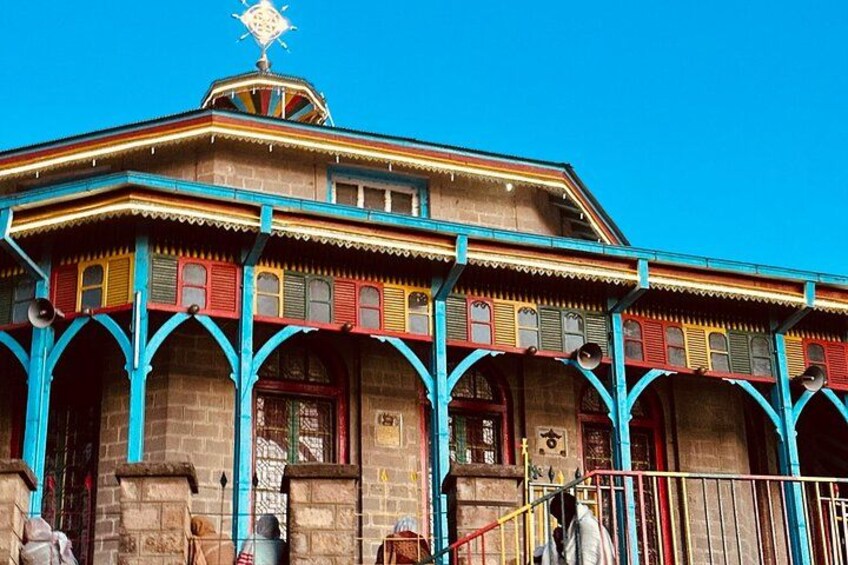 Un edificio colorido con un diseño tradicional, que presenta varios arcos y un techo decorativo. 2