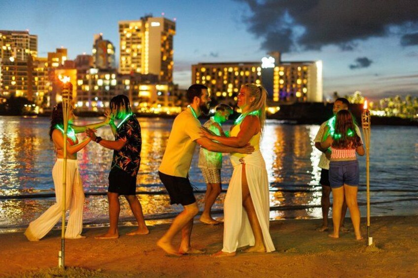 People holding torches with green lights, standing by a waterfront with buildings in the background. 4