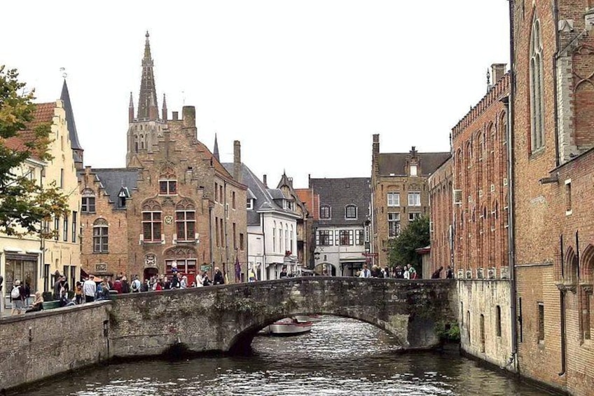 A historic stone bridge over a canal with buildings on either side. 2