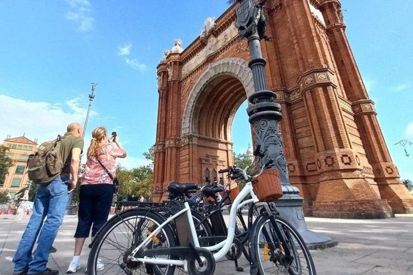 A large red archway, a white bicycle, and a person taking a photo. 3