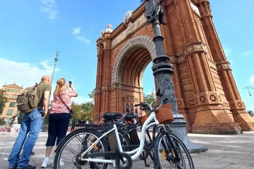 A large red archway, a white bicycle, and a person taking a photo. 3