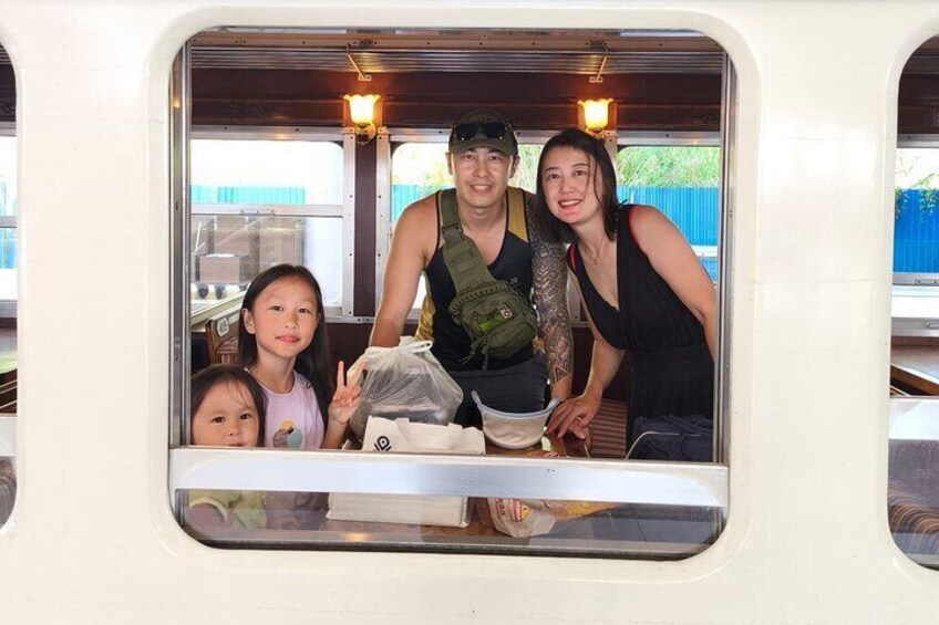 A family inside a vehicle with a table and food items. 2