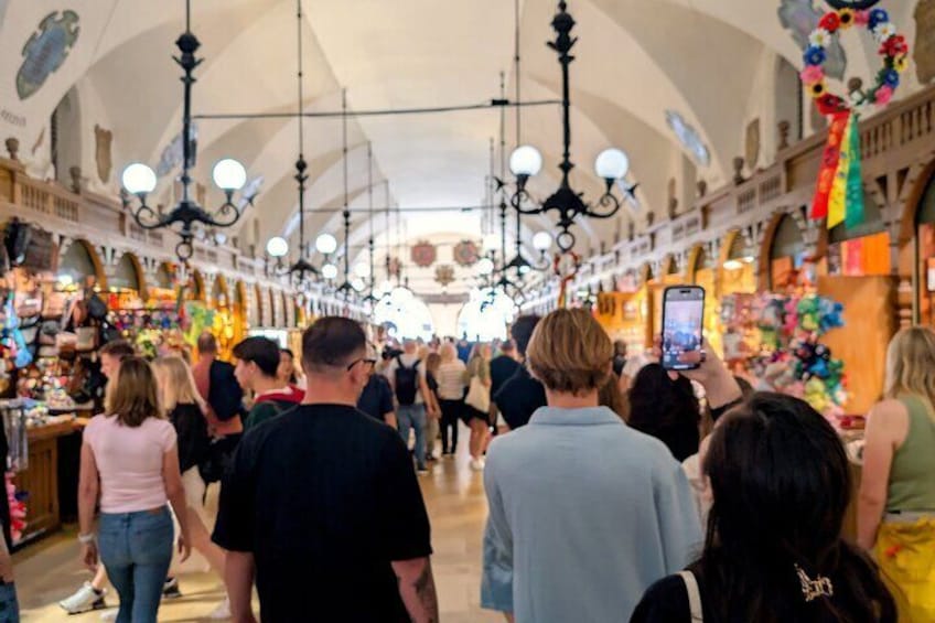 Un mercado cubierto concurrido, gente caminando y comprando. 1