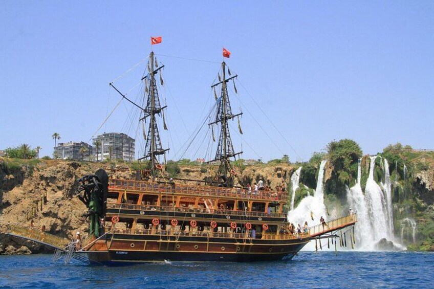 Ein großes Boot mit zwei Masten und einer türkischen Flagge, das an einem Wasserfall liegt. 2
