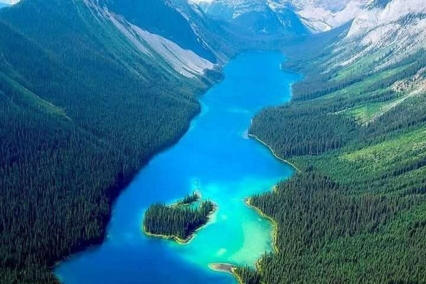 Un lac turquoise, entouré de forêts denses et de montagnes. 2